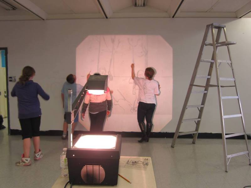 Transferring the preliminary design to the wall with the help of an overhead projector.